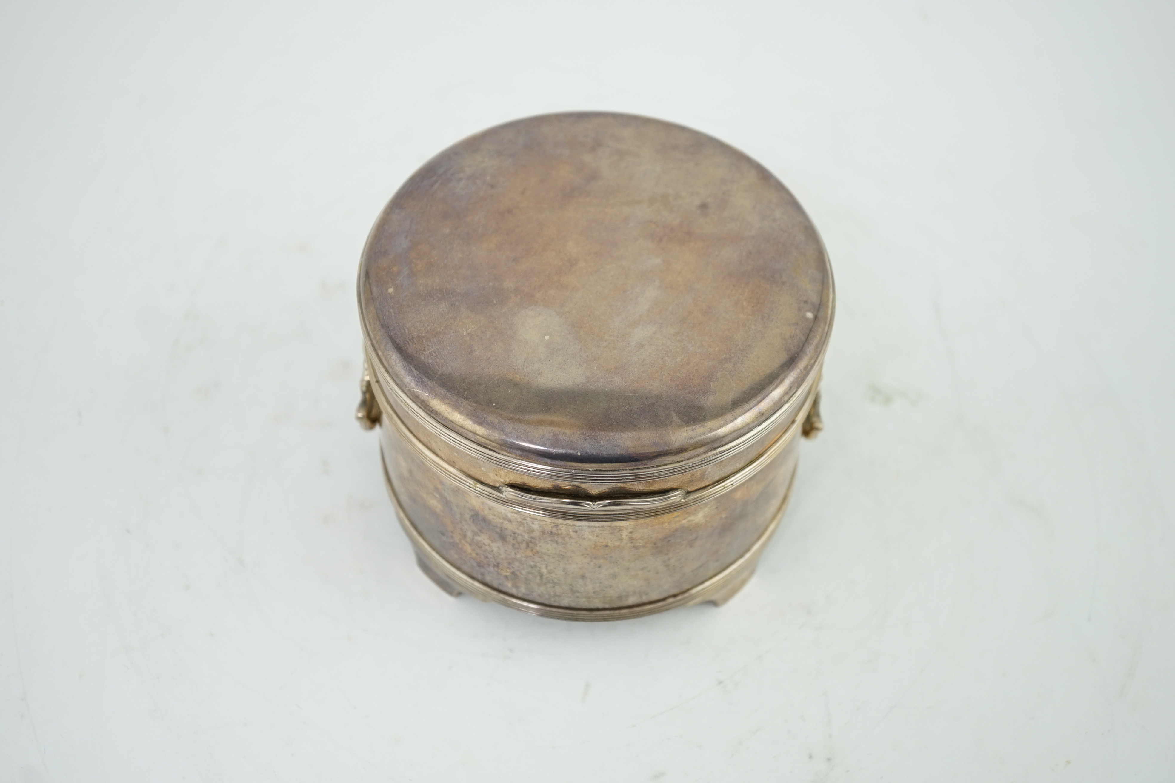 A George V silver circular two handed biscuit box, with hinged cover, by Asprey & Co Ltd